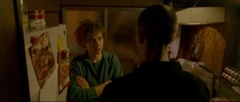 Movie still from “Enter the Void” (2009), directed by Gaspar Noé – Two people sitting in front of each other in front of a mirror; Medium shot, Over the shoulder angle