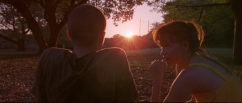 Movie still from “Enter the Void” (2009), directed by Gaspar Noé – Two children sitting in the grass looking at the sunset; Medium shot, Low angle