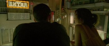 Movie still from “Enter the Void” (2009), directed by Gaspar Noé – A man and a woman sitting in front of each other; Medium shot, Over the shoulder angle