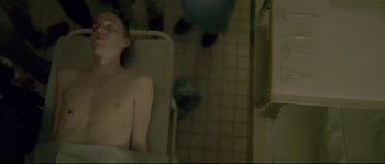 Movie still from “Enter the Void” (2009), directed by Gaspar Noé – A man sitting in a bath tub next to a sink; Medium shot, Overhead angle