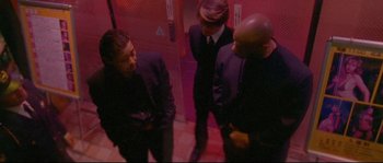 Movie still from “Enter the Void” (2009), directed by Gaspar Noé – A group of men standing next to each other; Medium shot, Low angle