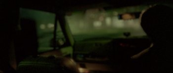 Movie still from “Enter the Void” (2009), directed by Gaspar Noé – A blurry image of a car in the dark; Close Up shot, Over the shoulder angle