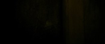 Movie still from “Enter the Void” (2009), directed by Gaspar Noé – A dark room with a light shining on the wall; Close Up shot, Low angle