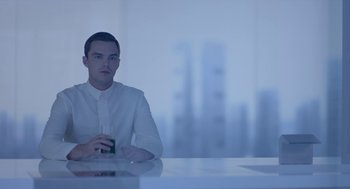 Movie still from “Equals” (2015), directed by Drake Doremus – A man sitting at a table holding a glass of wine; Medium shot, Over the shoulder angle