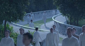 Movie still from “Equals” (2015), directed by Drake Doremus – A group of men in white suits walking down a street; Wide shot, High angle