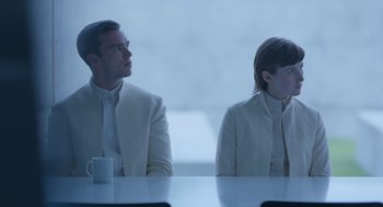 Movie still from “Equals” (2015), directed by Drake Doremus – A man and a woman sitting at a table with a coffee cup; Medium shot, Over the shoulder angle