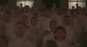 Movie still from “Equals” (2015), directed by Drake Doremus – A large group of people in white shirts and ties; Medium shot, High angle
