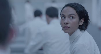 Movie still from “Equals” (2015), directed by Drake Doremus – A woman in a white shirt is looking at the camera; Close Up shot, Over the shoulder angle