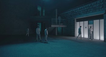 Movie still from “Equals” (2015), directed by Drake Doremus – A group of people standing on a brick floor; Extreme Wide shot, Low angle
