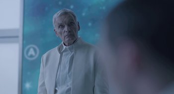 Movie still from “Equals” (2015), directed by Drake Doremus – An older man in a white suit looking at the camera; Close Up shot, Over the shoulder angle