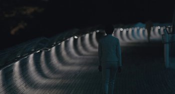 Movie still from “Equals” (2015), directed by Drake Doremus – A person is walking down a ramp at night; Extreme Wide shot, High angle