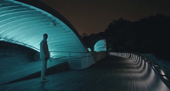 Movie still from “Equals” (2015), directed by Drake Doremus – A man standing in front of a bridge at night; Extreme Wide shot, Low angle