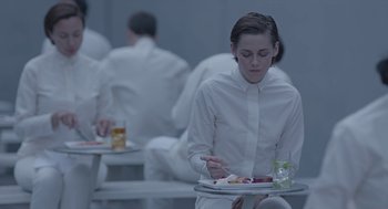 Movie still from “Equals” (2015), directed by Drake Doremus – A woman in white shirt holding a plate of food; Medium shot, High angle