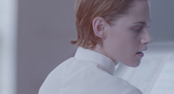 Movie still from “Equals” (2015), directed by Drake Doremus – A person with a white shirt and a red hair style; Close Up shot, Over the shoulder angle