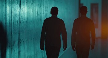 Movie still from “Equals” (2015), directed by Drake Doremus – Two men are walking down the street in the dark; Wide shot, Low angle