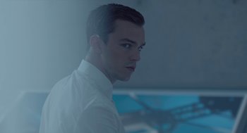 Movie still from “Equals” (2015), directed by Drake Doremus – A man in a white dress shirt is looking at the camera; Close Up shot, Over the shoulder angle