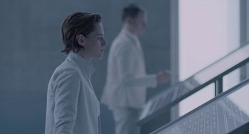Movie still from “Equals” (2015), directed by Drake Doremus – A man in a white suit is standing next to another man in a white suit; Medium shot, Over the shoulder angle