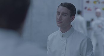 Movie still from “Equals” (2015), directed by Drake Doremus – A man wearing a white shirt is looking to his left; Close Up shot, Over the shoulder angle
