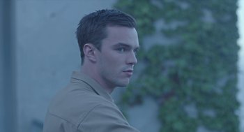 Movie still from “Equals” (2015), directed by Drake Doremus – A young man is standing in front of a wall; Close Up shot, High angle