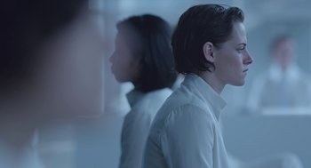Movie still from “Equals” (2015), directed by Drake Doremus – Two people standing side - by - side in front of a window; Medium shot, Over the shoulder angle
