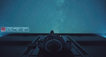 Movie still from “Equals” (2015), directed by Drake Doremus – A person sitting in front of a projector screen; Wide shot, Overhead angle