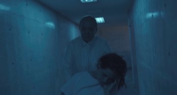 Movie still from “Equals” (2015), directed by Drake Doremus – A man and a woman standing in a dark room; Medium shot, High angle