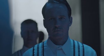 Movie still from “Equals” (2015), directed by Drake Doremus – A person wearing a shirt and tie; Close Up shot, Over the shoulder angle
