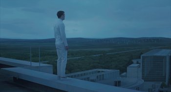 Movie still from “Equals” (2015), directed by Drake Doremus – A man standing on top of a building looking out over a field; Wide shot, Low angle
