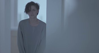 Movie still from “Equals” (2015), directed by Drake Doremus – A woman standing in front of a wall; Medium shot, Over the shoulder angle
