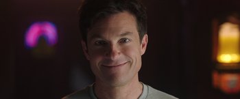 Movie still from “Game Night” (2018), directed by John Francis Daley – A person smiling for the camera; Close Up shot, Over the shoulder angle