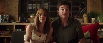 Movie still from “Game Night” (2018), directed by John Francis Daley – A man and a woman standing next to each other; Medium shot, Over the shoulder angle