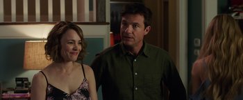 Movie still from “Game Night” (2018), directed by John Francis Daley – A man and a woman standing next to each other in a room; Medium shot, Over the shoulder angle