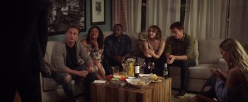 Movie still from “Game Night” (2018), directed by John Francis Daley – A group of people sitting around a coffee table; Wide shot, High angle