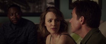 Movie still from “Game Night” (2018), directed by John Francis Daley – A person sitting on a couch; Close Up shot, Over the shoulder angle