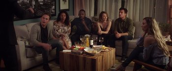 Movie still from “Game Night” (2018), directed by John Francis Daley – A group of people sitting around a coffee table; Wide shot, High angle