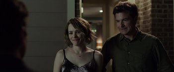 Movie still from “Game Night” (2018), directed by John Francis Daley – A man and a woman standing next to each other; Medium shot, Over the shoulder angle