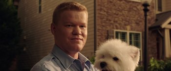 Movie still from “Game Night” (2018), directed by John Francis Daley – A man and a dog are posing for a picture; Close Up shot, Low angle