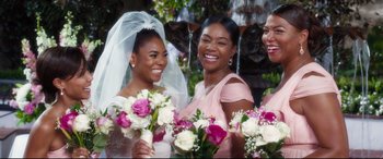 Movie still from “Girls Trip” (2017), directed by Malcolm D. Lee – A group of women standing next to each other holding bouquets; Close Up shot, Over the shoulder angle