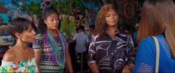 Movie still from “Girls Trip” (2017), directed by Malcolm D. Lee – Two women standing next to each other in front of a painting; Medium shot, Over the shoulder angle