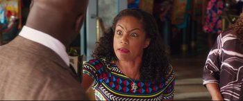Movie still from “Girls Trip” (2017), directed by Malcolm D. Lee – A woman with curly black hair wearing a multicolored shirt; Close Up shot, Over the shoulder angle