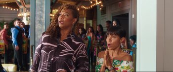 Movie still from “Girls Trip” (2017), directed by Malcolm D. Lee – Two women are standing in a room and clapping; Medium shot, Over the shoulder angle