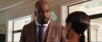 Movie still from “Girls Trip” (2017), directed by Malcolm D. Lee – A man in a suit and tie talking to a woman in front of a window; Close Up shot, Over the shoulder angle