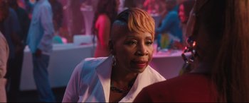 Movie still from “Girls Trip” (2017), directed by Malcolm D. Lee – An older woman with short hair sitting at a party; Close Up shot, Over the shoulder angle