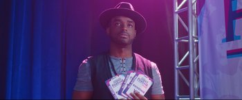 Movie still from “Girls Trip” (2017), directed by Malcolm D. Lee – A man in a hat holding a stack of tickets; Close Up shot, High angle