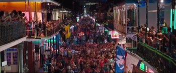 Movie still from “Girls Trip” (2017), directed by Malcolm D. Lee – A crowd of people walking down a street at night; Extreme Wide shot, Overhead angle