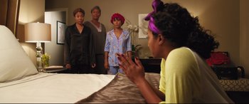 Movie still from “Girls Trip” (2017), directed by Malcolm D. Lee – A group of women standing around a bed; Medium shot, Over the shoulder angle