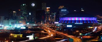 Movie still from “Girls Trip” (2017), directed by Malcolm D. Lee – A night time view of a city with a full moon; Extreme Wide shot, Low angle