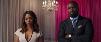 Movie still from “Girls Trip” (2017), directed by Malcolm D. Lee – A man and a woman standing next to each other in front of a chandelier; Medium shot, Over the shoulder angle