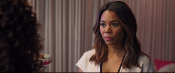 Movie still from “Girls Trip” (2017), directed by Malcolm D. Lee – A woman with long hair looking at the camera; Close Up shot, Over the shoulder angle