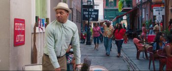 Movie still from “Girls Trip” (2017), directed by Malcolm D. Lee – A group of people walking down a street; Medium shot, Over the shoulder angle